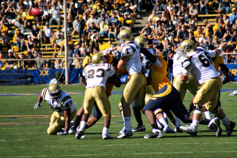 an image of group of people playing football in front of a crowd