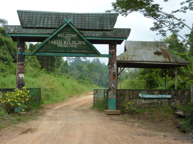 a dirt road with a green sign on it