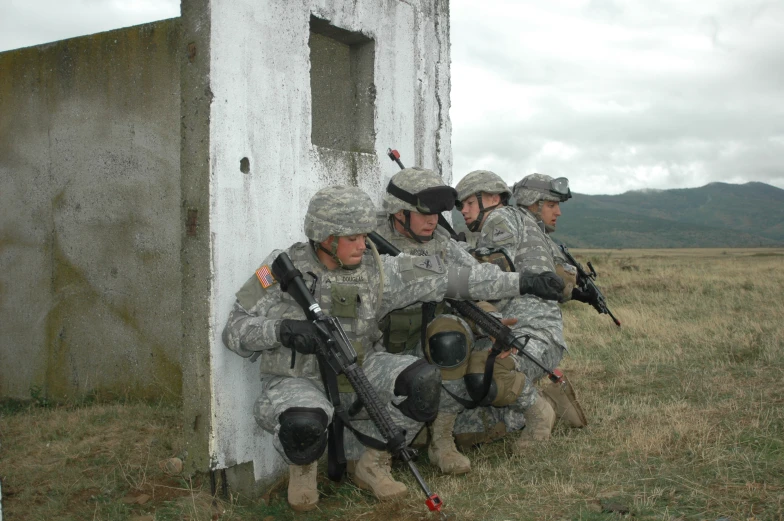 several soldiers sitting on a wall with guns