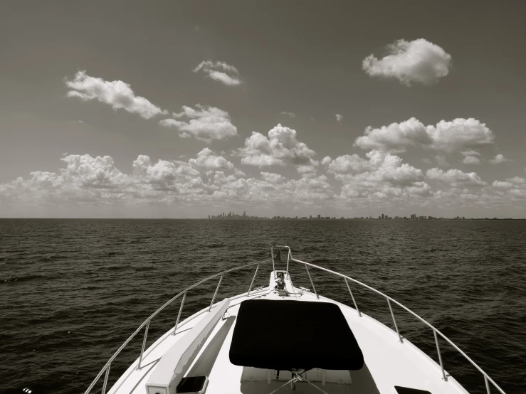 a boat sailing across the open ocean under a cloudy sky