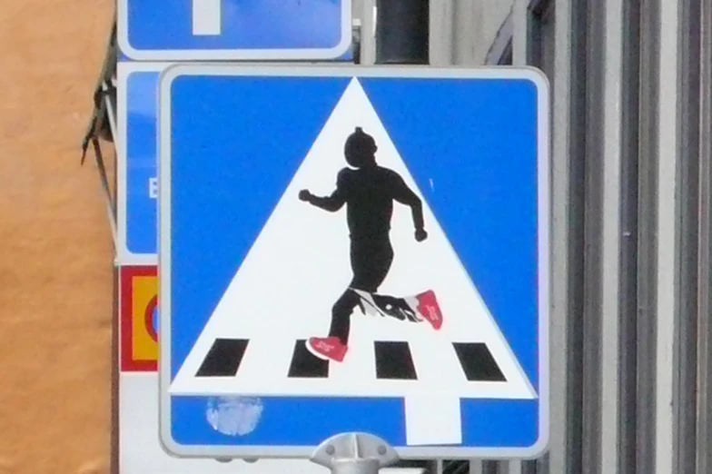 a pedestrian crossing sign and a white arrow on the blue