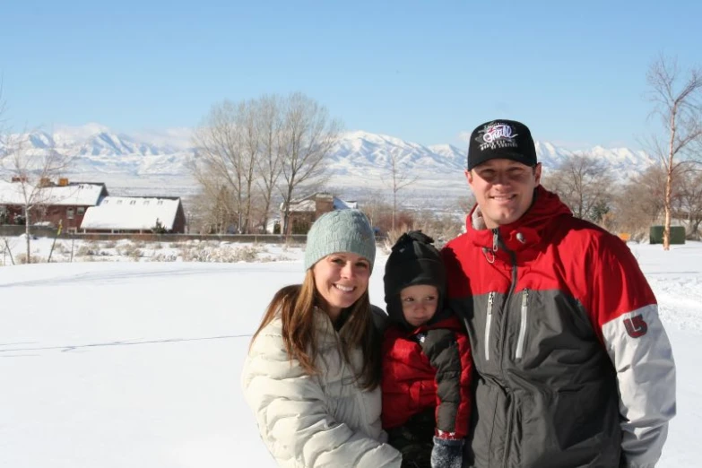 a man and woman and child pose in the snow