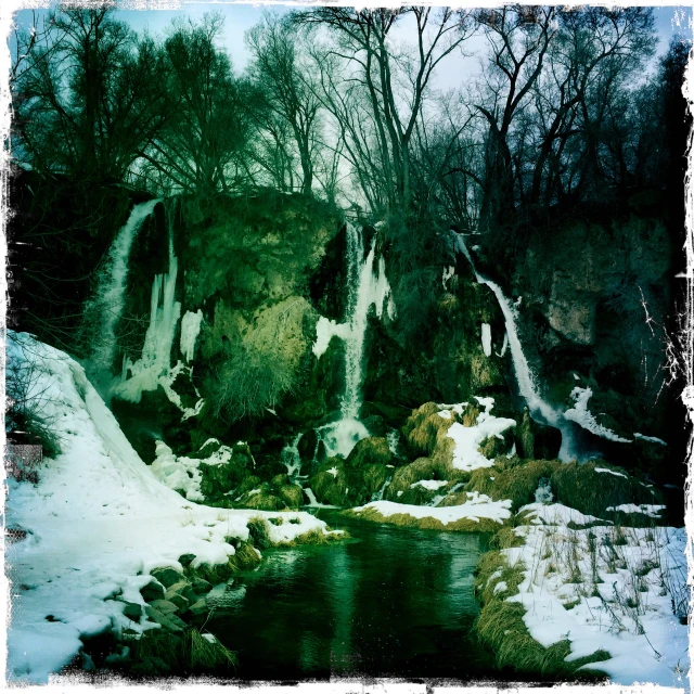 a small creek runs through some snow covered ground