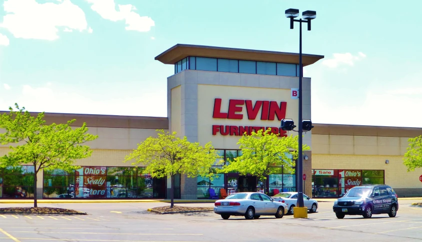 a parking lot with two parked cars in front of a luknet store