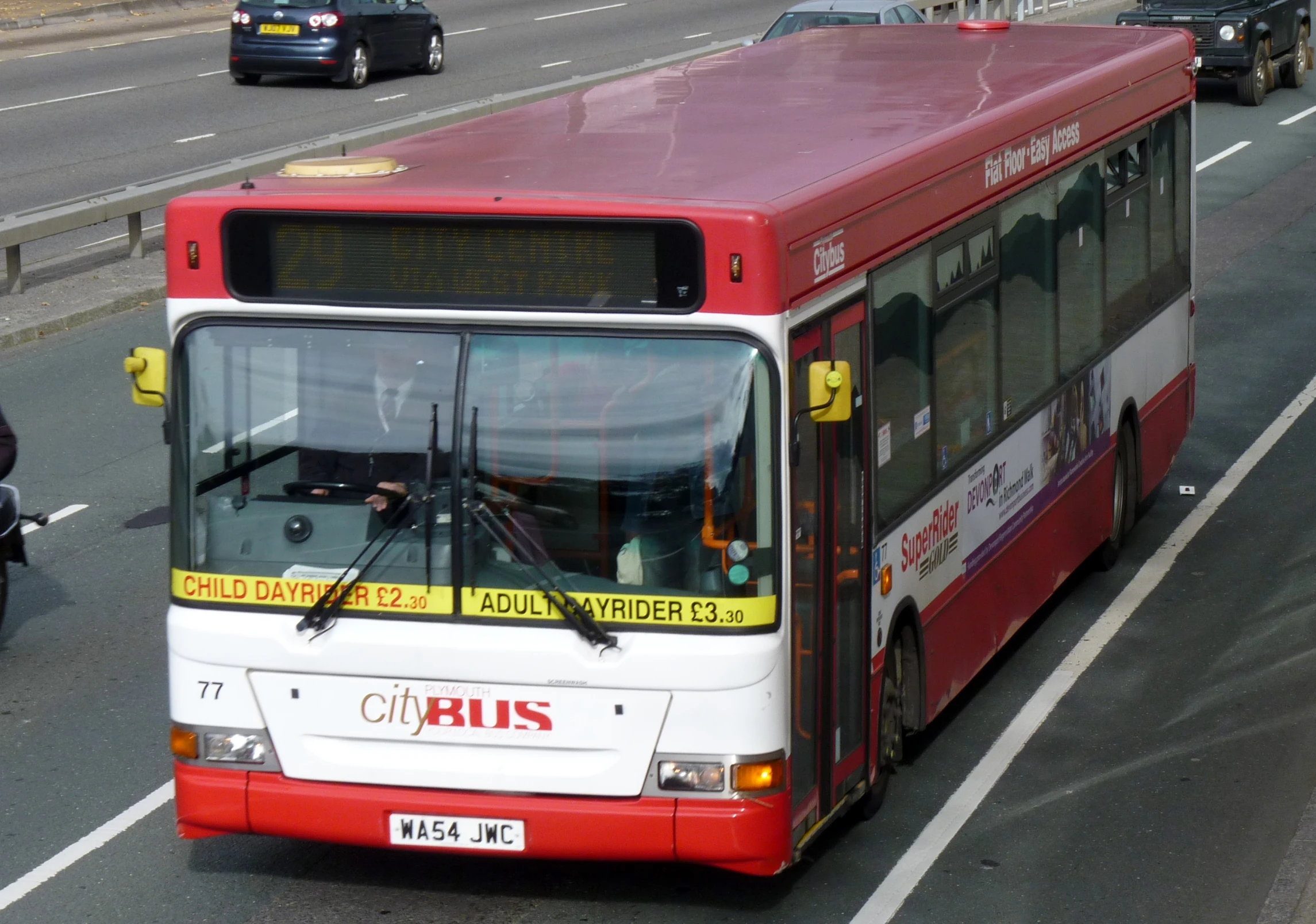 the red and white bus is on the street