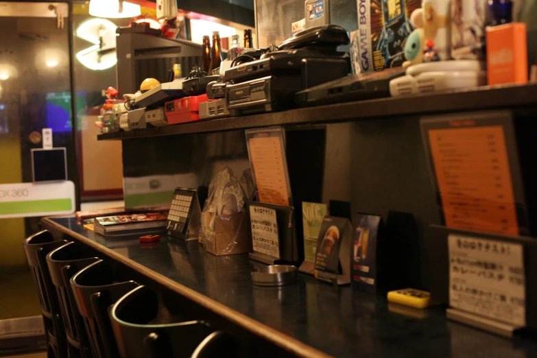 some cups of wine are on a shelf by a book case