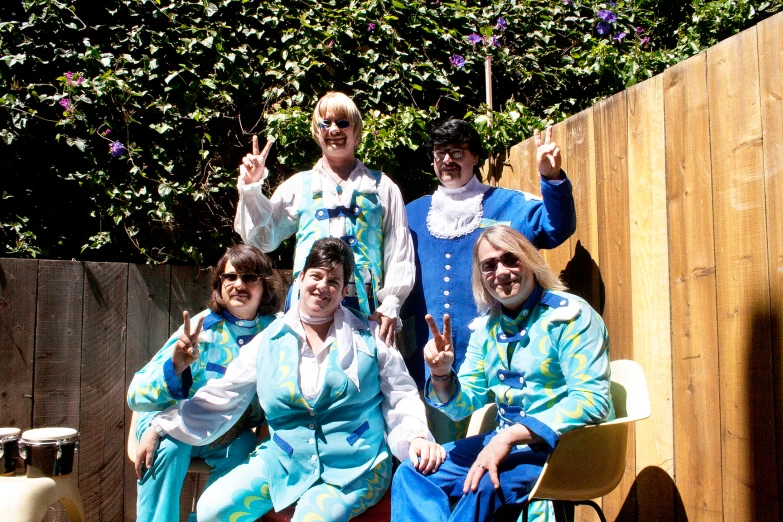 group of people in brightly colored costume sitting and waving