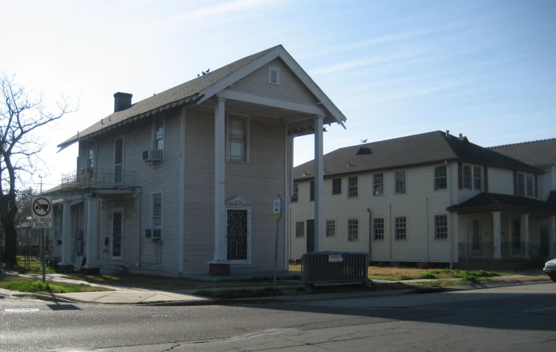 a white house sitting at the corner of a street