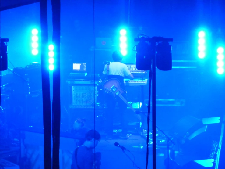 the stage lights reflect off a darkened concert hall as the band performs