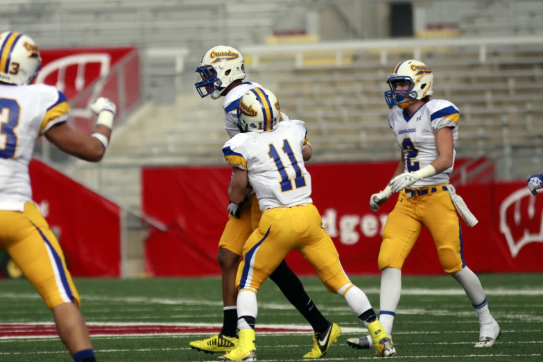 the three players in blue and yellow uniforms are playing football