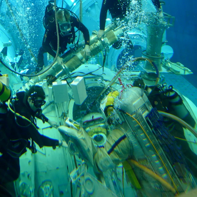 two people in a diving suit near the camera on a small boat