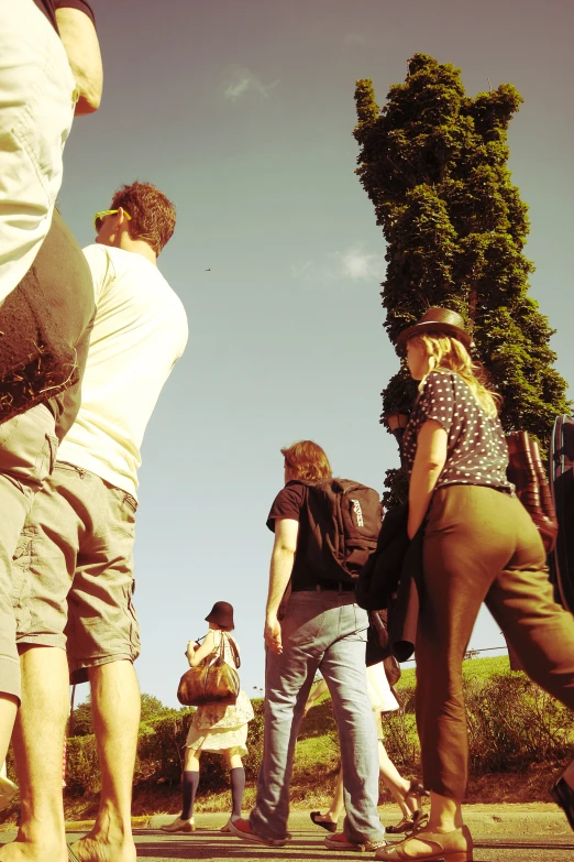 people are standing in the park, one man is wearing a back pack