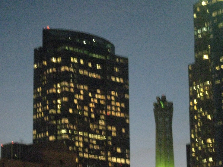 two tall skyscrs at night, seen from across the street