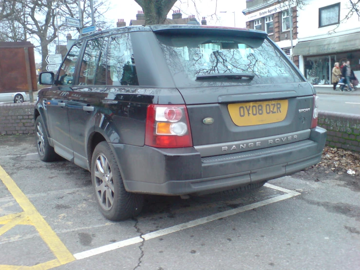 a grey range rover parked in the street with no people around