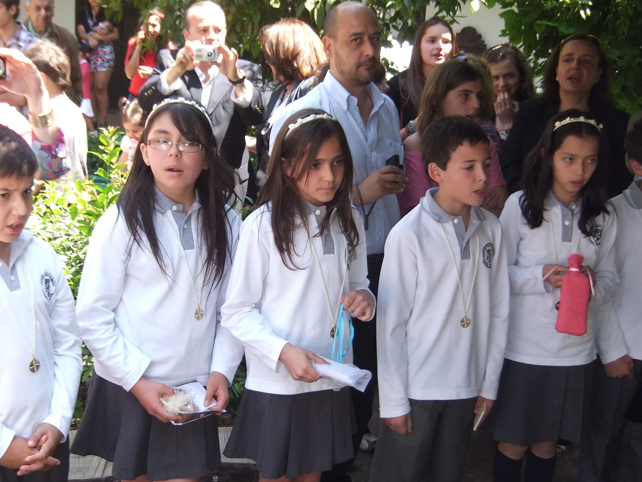 group of children wearing white uniforms standing in line