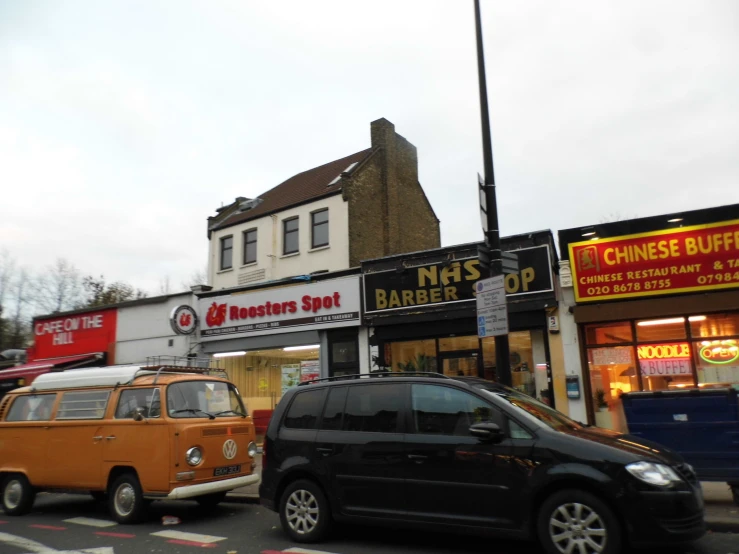 a street intersection in front of stores, including a van