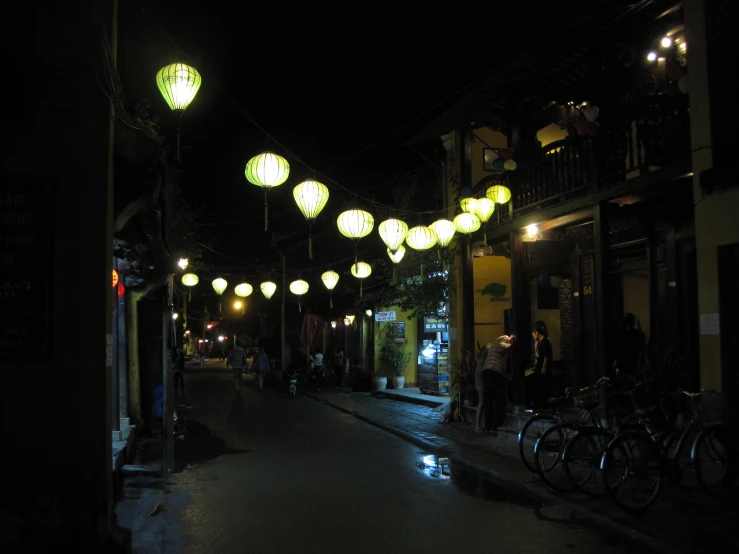 some green and yellow lights are hanging over a street