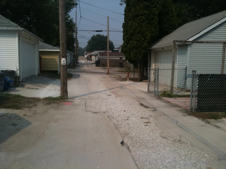 an empty road in a neighborhood surrounded by garages