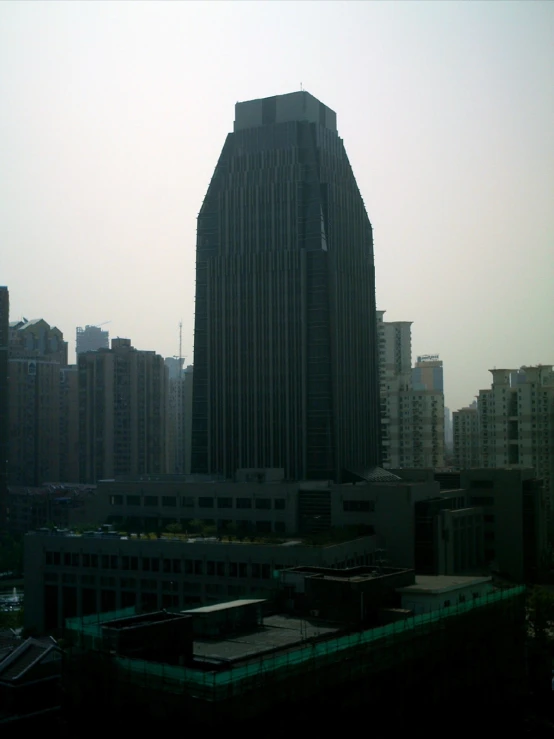 there are many tall buildings against the hazy sky