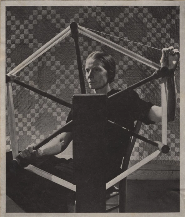 a woman sitting inside of a wooden chair with a hammer