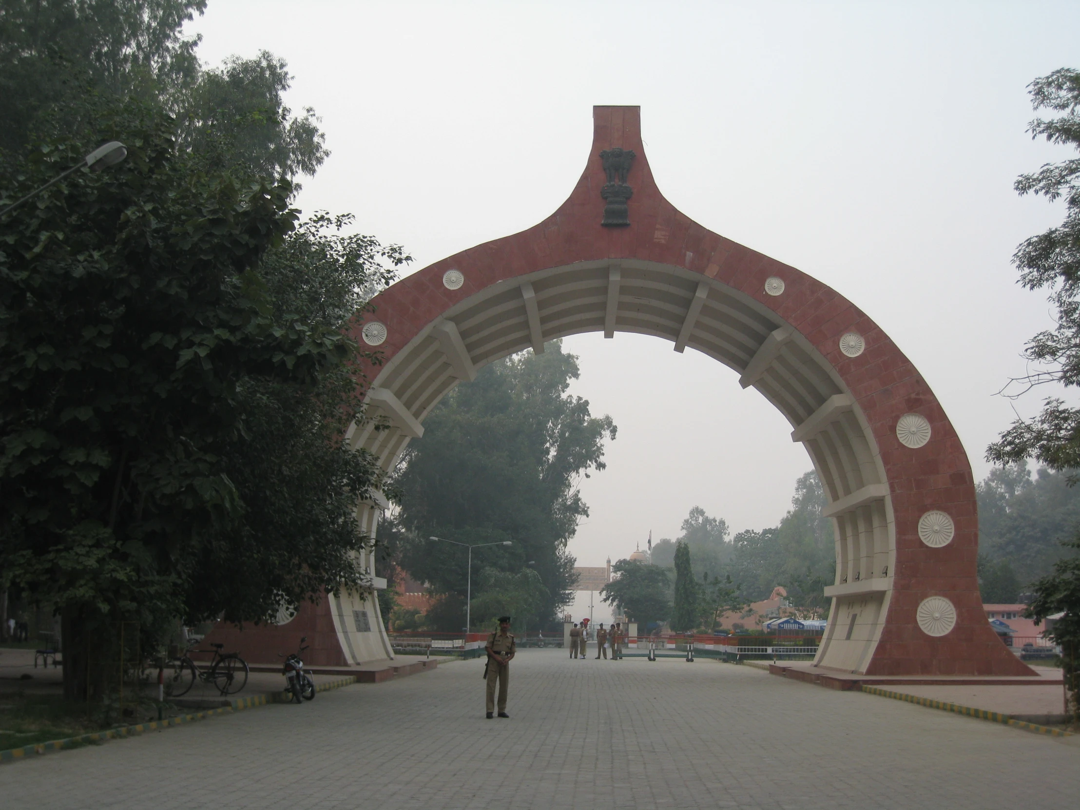 a walkway with a man walking up the middle and two people on the sidewalk