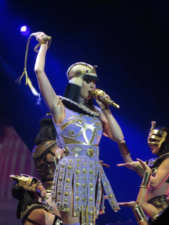 woman dressed in costume performing on stage with two other people