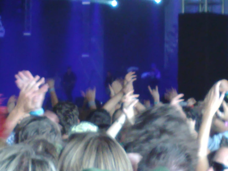 people standing on stage with their arms in the air