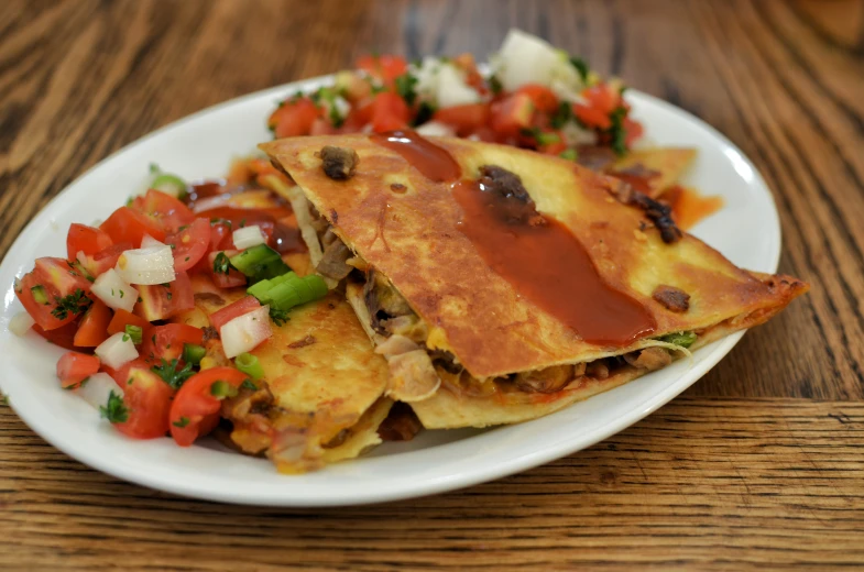 a plate topped with tortilla and veggies next to a cup