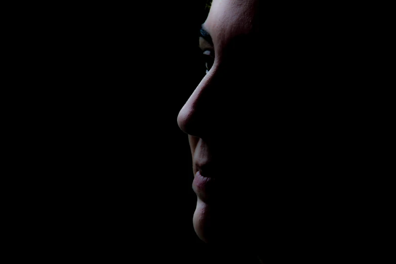 a close - up s of a man's face in the dark