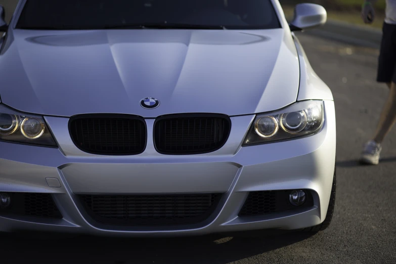 the white bmw is parked on the side of the road