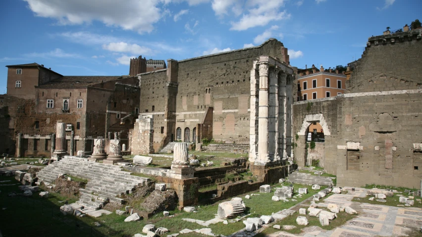 ruins with buildings in the background and a sky