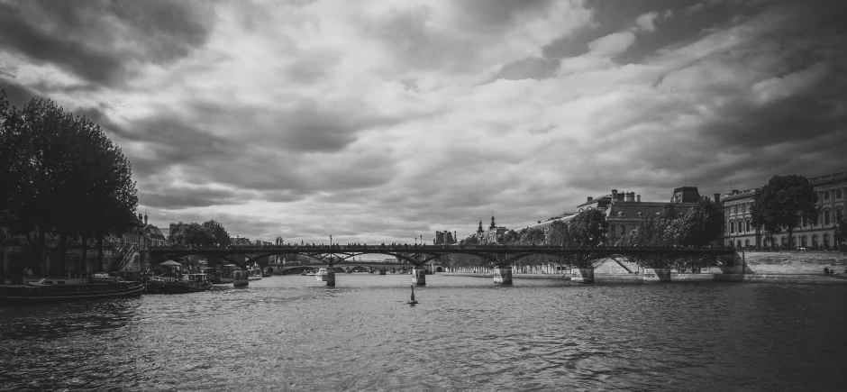 an old po of a river with a bridge in the background