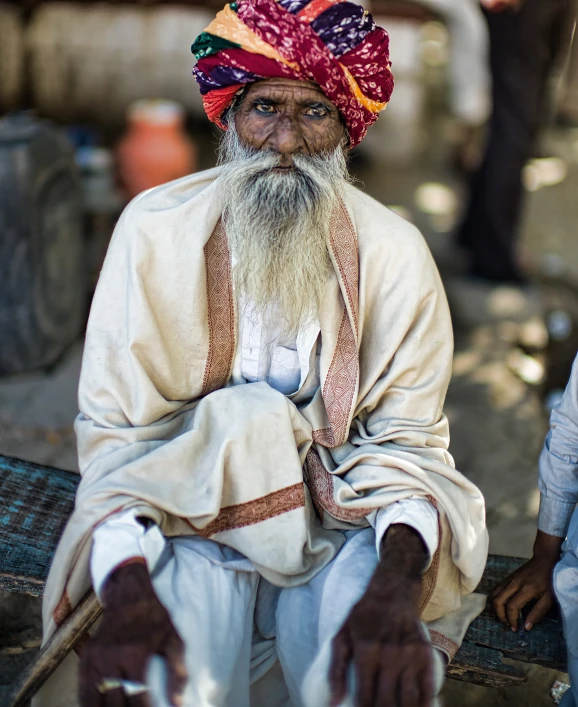 old man with long white beard sitting in front of another person