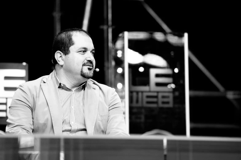 a man sitting at a desk on top of a laptop computer