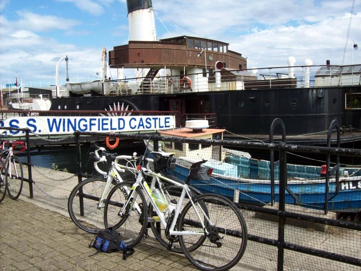 two bikes are parked next to a dock with a lighthouse