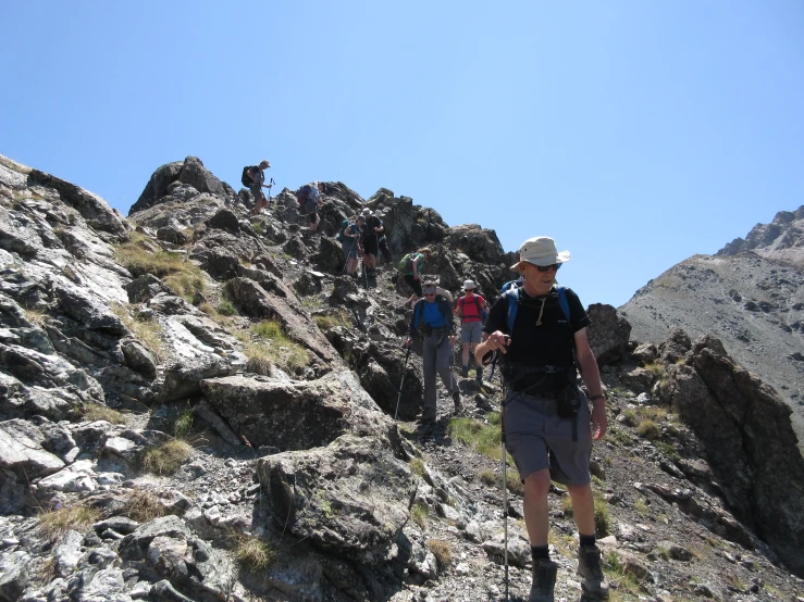 a man in backpack walking on a mountain with other people