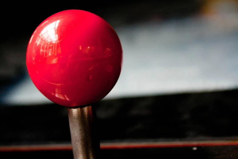 an orange ball on top of a wooden stick