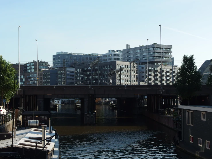 a small barge floats down the river with some buildings in the background