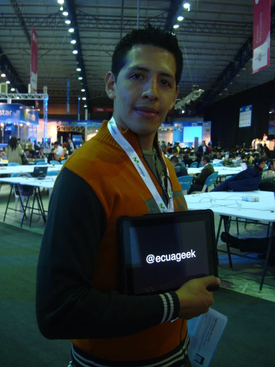 a young man holding an electronic device at a convention