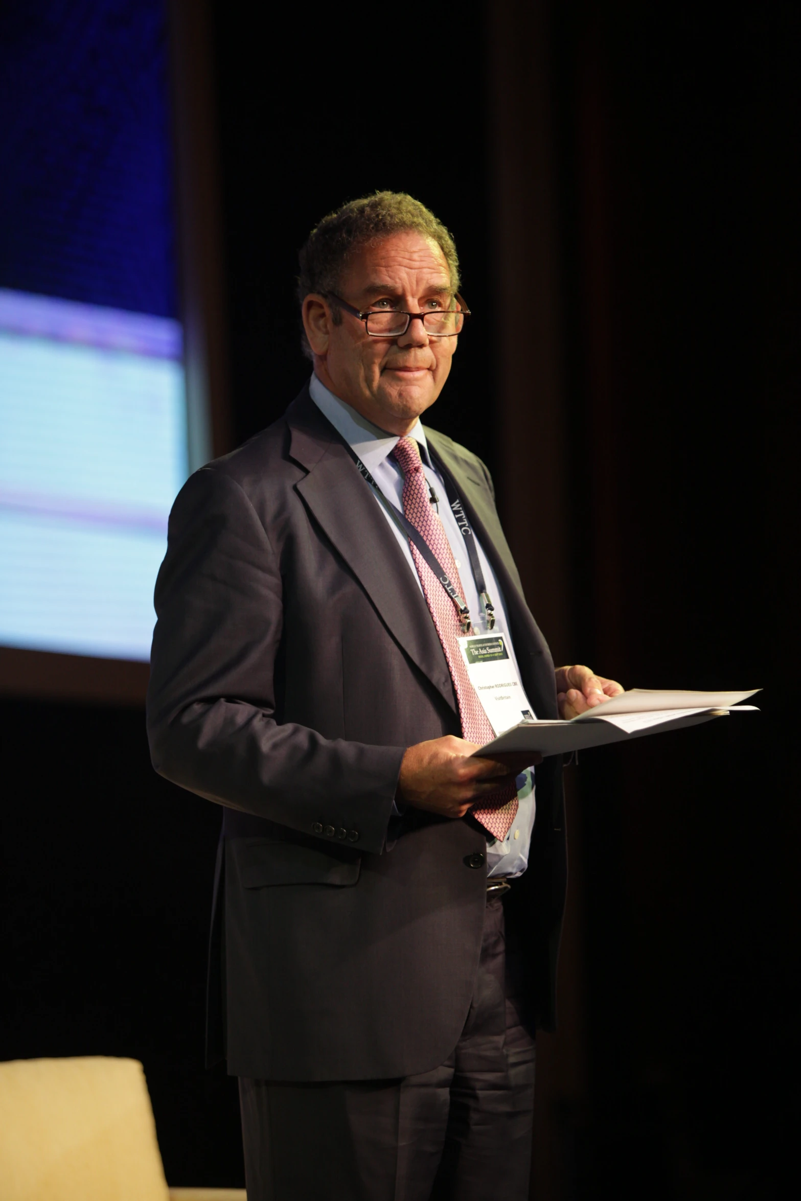 an older businessman is shown holding a document in his hands