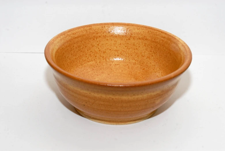 an orange bowl sitting on a white table