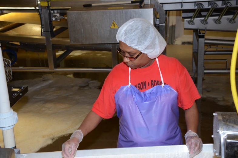 a person with a kitchen apron putting soing in a bag