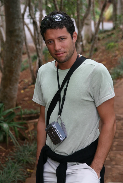 a man posing for a camera in the woods