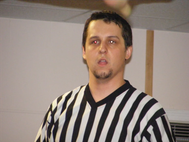 a man with an eye patch wearing a referee uniform