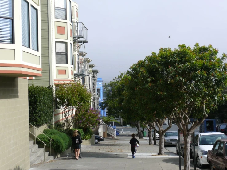 two people walking along the street near the houses