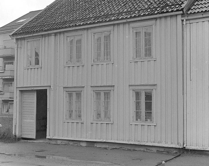 two people sitting at the door of a small wooden building