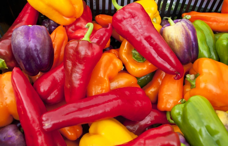 various colors of peppers are in a basket