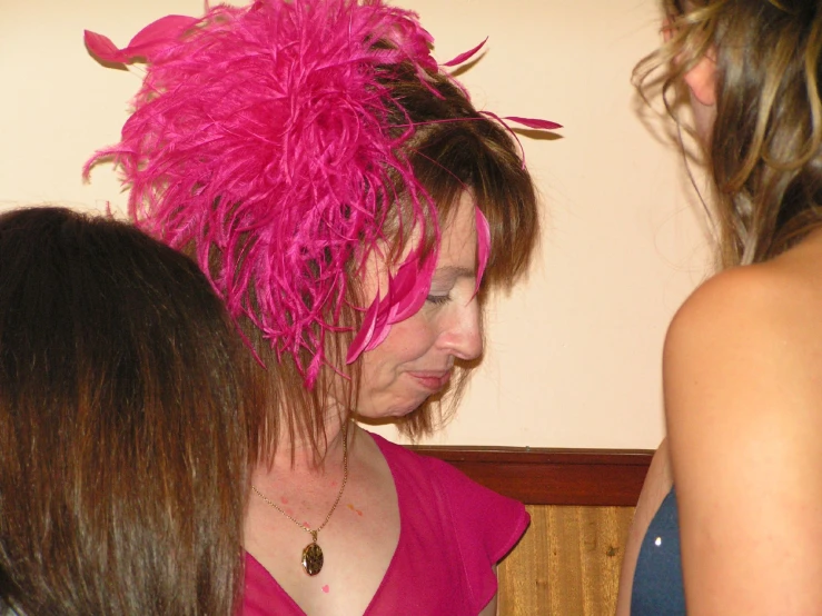 a woman with pink feathers and beads on her head