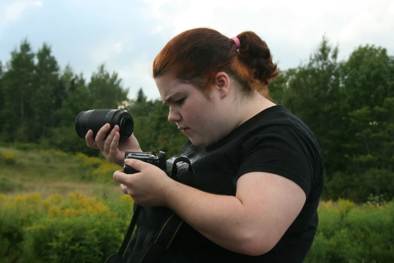 a woman holding a camera and using the phone
