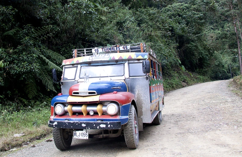 an old truck on the side of a dirt road